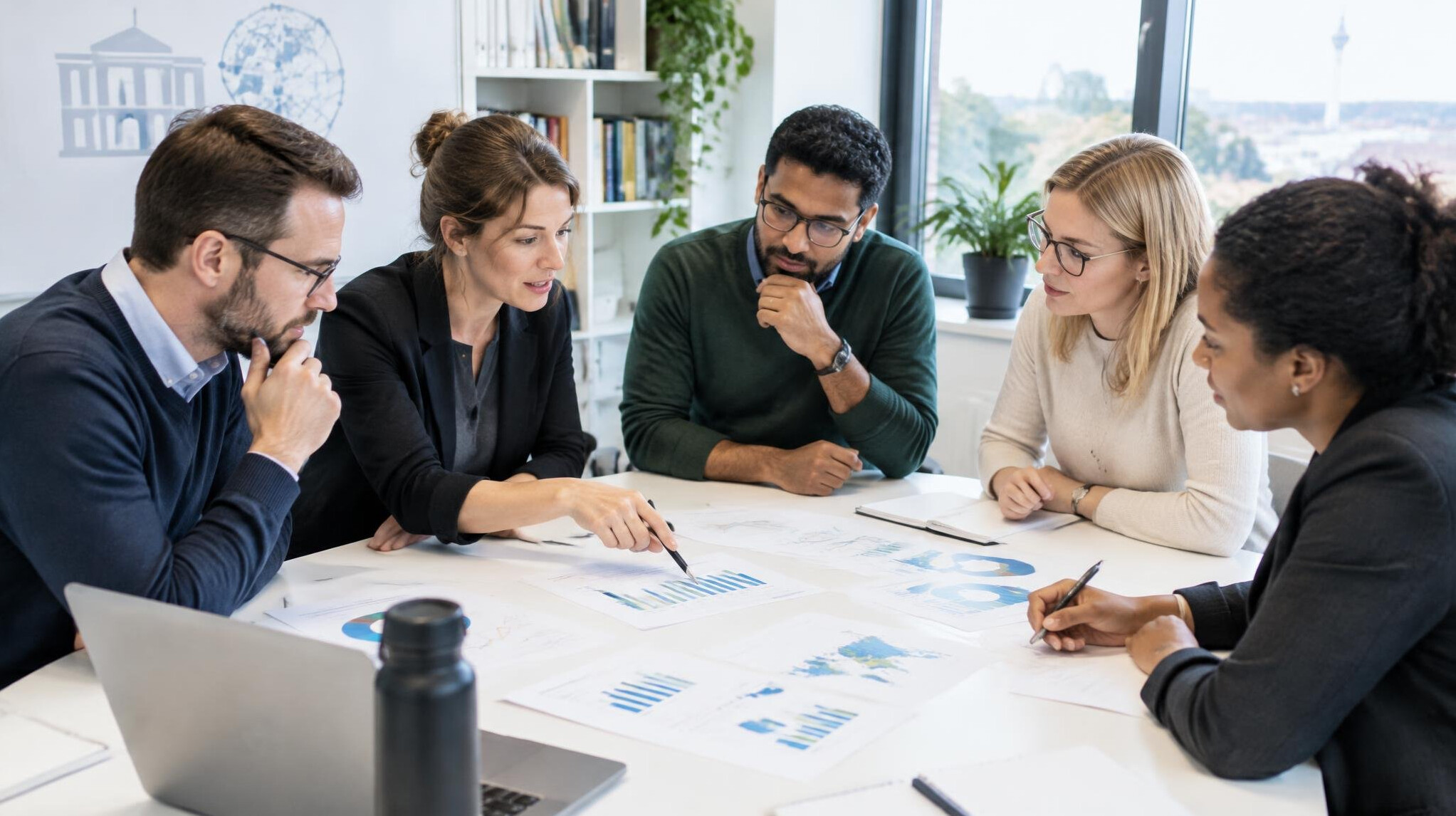 Research team analyzing data charts in a modern office